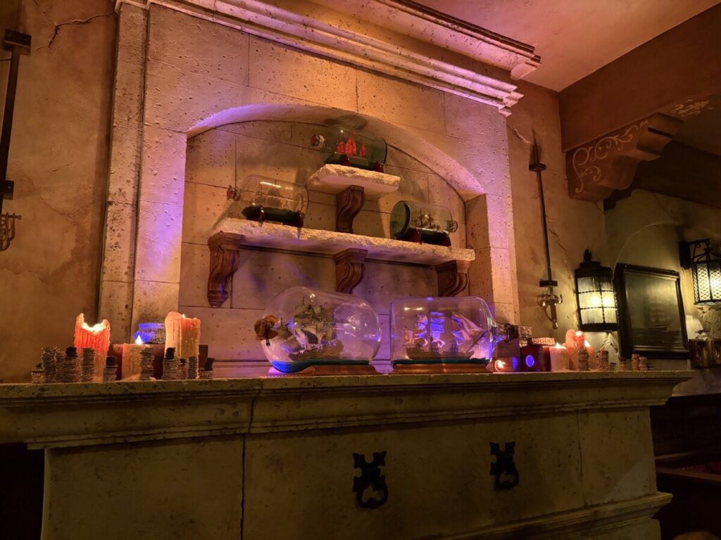 The fireplace with battling ships in a bottle at Beak and Barrel