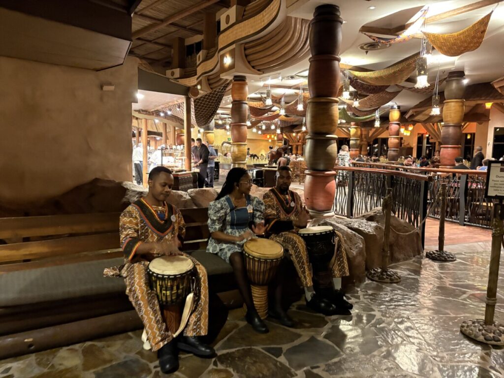 Cast Members playing drums outside Boma