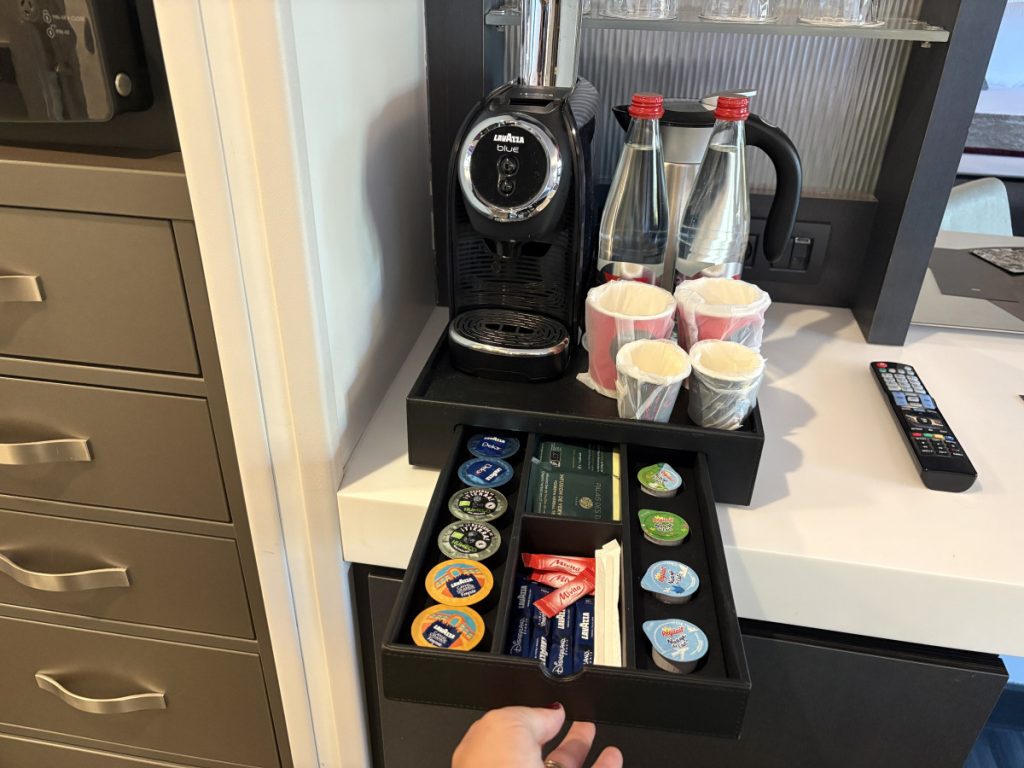 Lavazza machine with tea, coffee and espresso along with bottled water, branded paper cups and an electric kettle